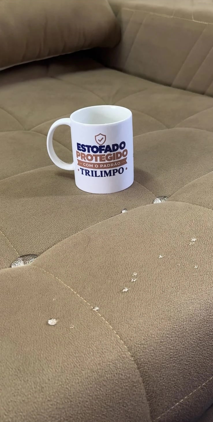 Caneca TRILIMPO sobre um sofá, com gotas de água sobre o tecido