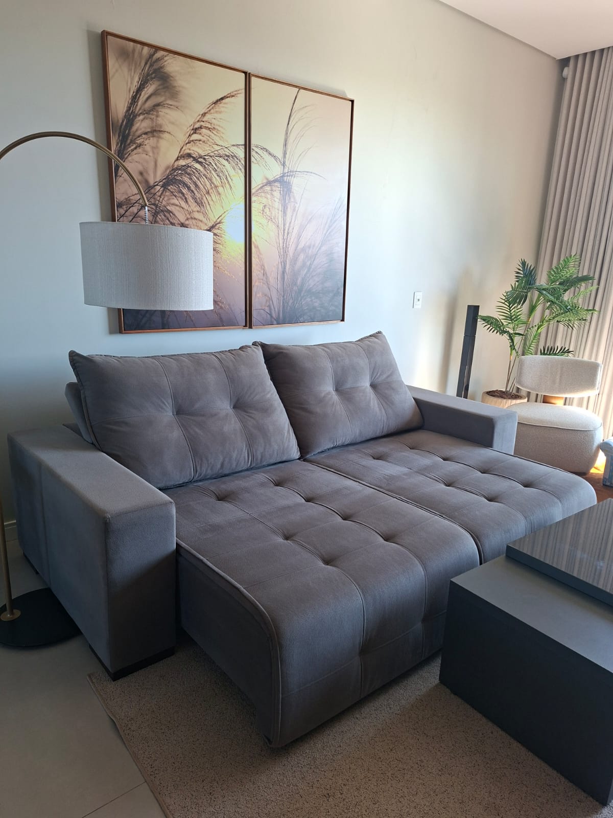 Sofá retrátil cinza em uma sala de estar, higienizado